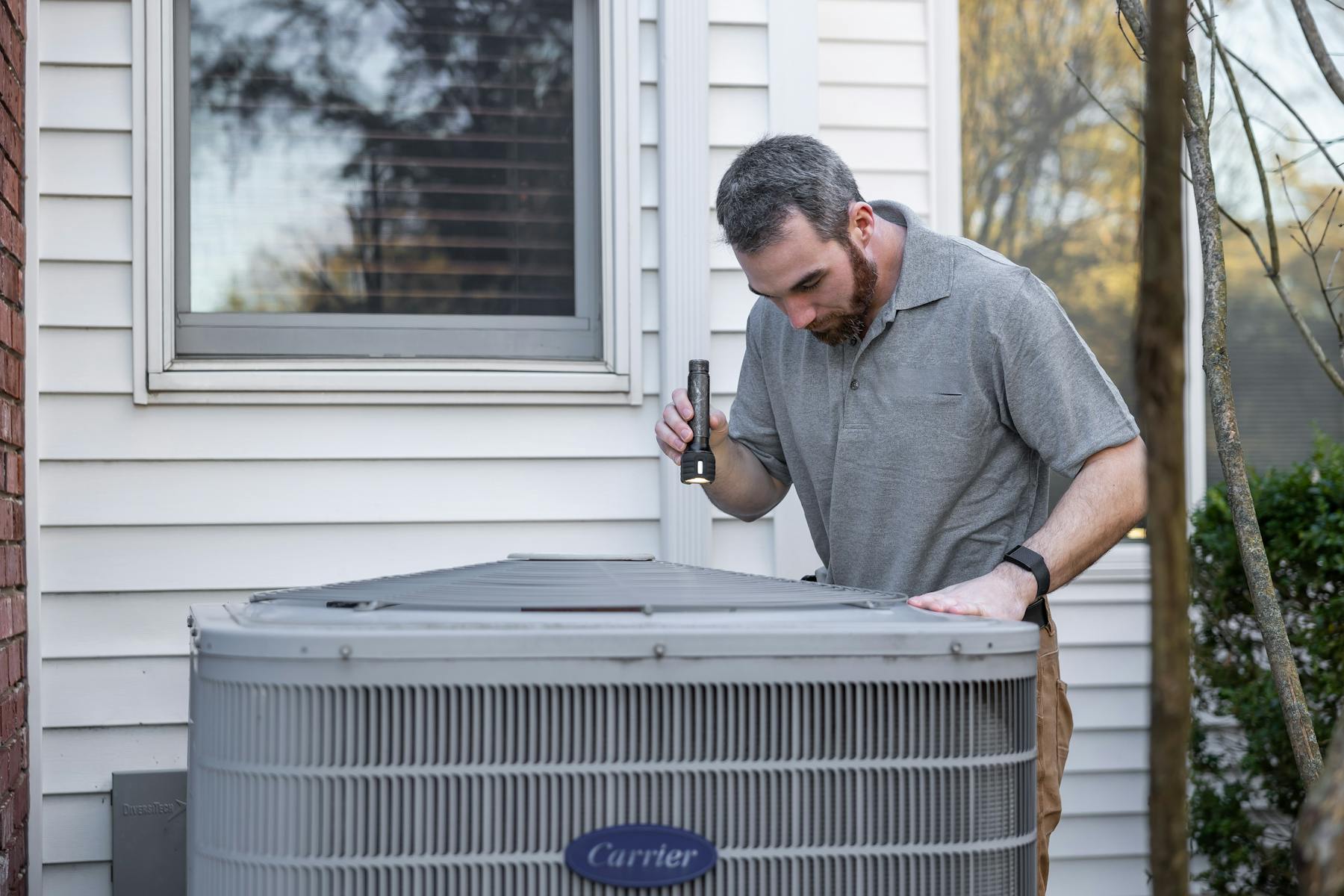 HVAC technician servicing an outdoor AC unit